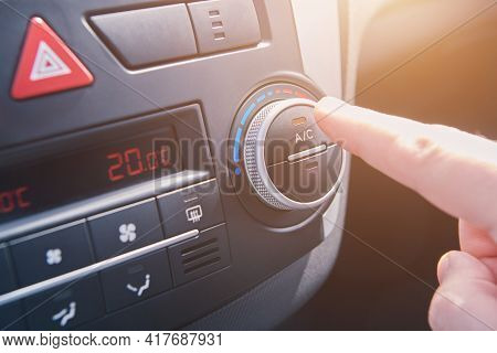 Man Hand Switches On The Air Conditioning In The Car. Driver Turning On Car Climate Control System. 