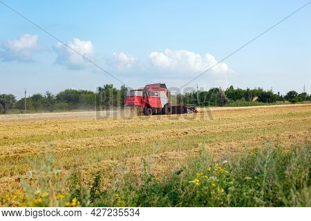 Wheat Harvesting On Field In Summer Season. Combine Harvester Harvests Ripe Wheat. Agriculture. Proc