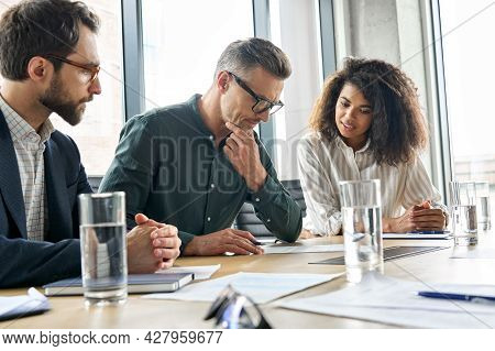 Focused Doubtful Mature Businessman Reading Contract Document Thinking Considering Risks With Profes