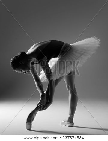 Young beautiful ballerina is posing in studio