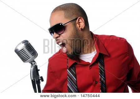 Young African American man singing into vintage microphone isolated over white