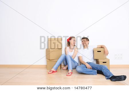 Young couple resting from moving into a new home. Great copy space.