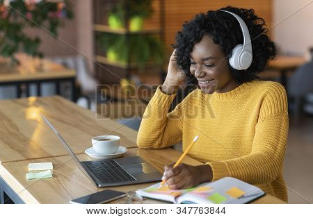 Smiling African American Girl In Wireless Headphones Looking At Laptop, Studying Foreign Language Th