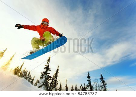 Snowboarder jumping through air with deep blue sky in background