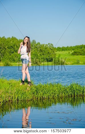 haired beautiful walks on the lake. girl in a summer forest near pond. Brunette standing near water. Girl in the forest near the pond.