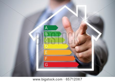 Businessman pointing to energy efficiency rating chart and house icon concept for performance, efficiency and environmental conservation