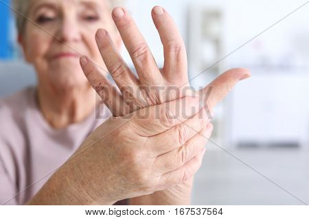 Elderly woman suffering from pain in hand, closeup