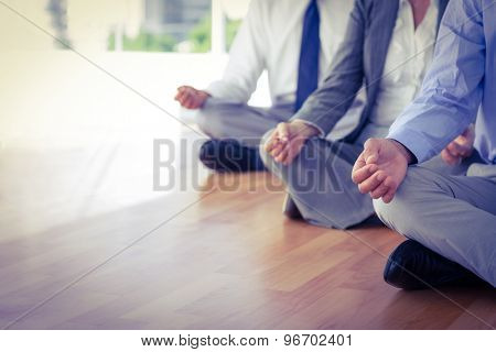 Close up view of business people doing yoga in office