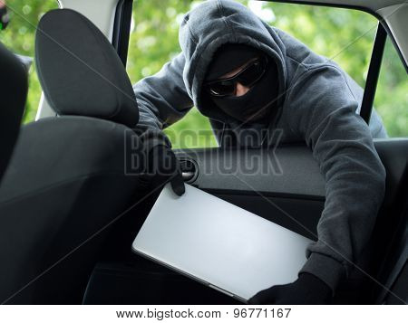 Car theft - a laptop being stolen through the window of an unoccupied car.  