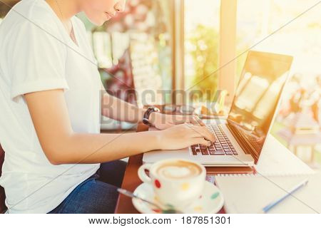 Female working on laptop in a cafe. woman using laptop in home. using laptop internet. hand using laptop in coffe shop. Business entrepreneur asian girl working online on laptop in cafe. business entrepreneur asian using laptop in home.