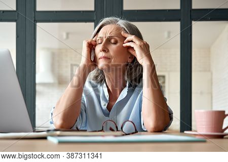 Tired Stressed Old Mature Business Woman Suffering From Headache At Work. Upset Sick Senior Middle A