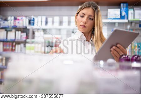 Young female pharmacist checking the inventory in a pharmacy