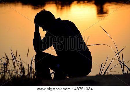 Depressed Man Sitting On Top Of Hands