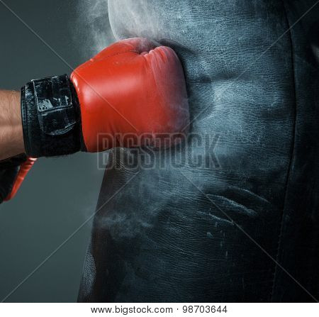 Hand  of boxer and punching bag over black background