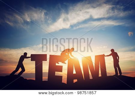 People connect letters to compose the team word. Teamwork concept, idea. Sunset positive light.