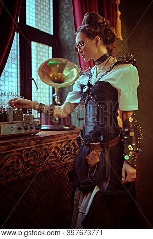 Fantasy world. Beautiful steampunk lady scientist inventor works in her laboratory with Victorian interior. 