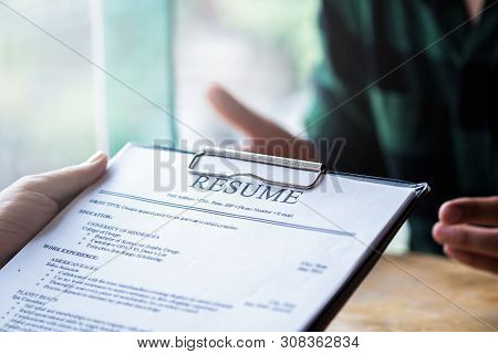 Interviewer Reading A Resume, Person Submits Job Application, Person Describe Yourself To Interviewe