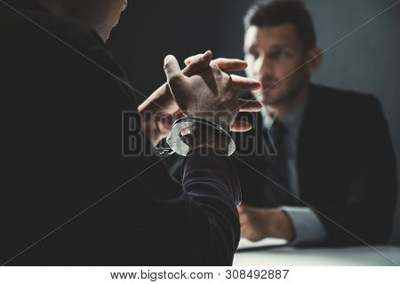 Criminal Man With Handcuffs Being Interviewed In Interrogation Room After Committed A Crime