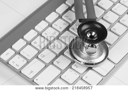 Medical stethoscope on computer keyboard. Concept of computer support. Black and white.