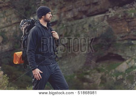 Adventure man hiking wilderness mountain with backpack, outdoor lifestyle survival vacation