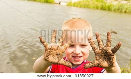 Child Playing Outdoor Showing Dirty Muddy Hands.