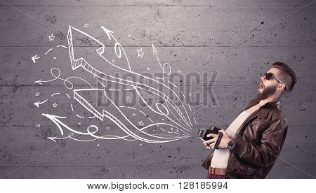 A hipster guy opening his point of view through looking a vintage camera concept with illustratied drawn arrows on urban wall