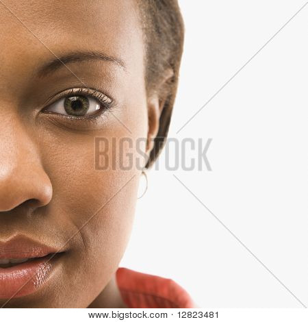 Close-up portret van Afro-Amerikaanse vrouw tegen witte achtergrond.