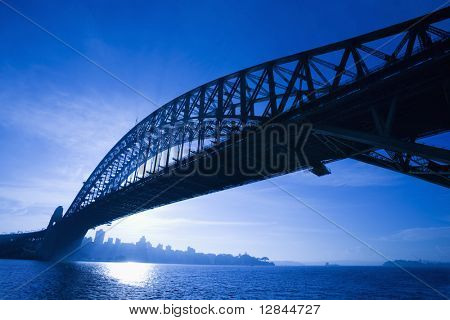 Sydney Harbour Bridge al tramonto con vista orizzonte distante e porto di Sydney, in Australia.