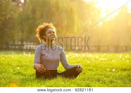 Happy Young Woman Sitting In Yoga Position