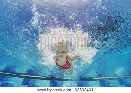 Child Swimming Underwater With Splashes In The Pool