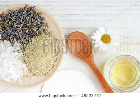 Cosmetic herbal ingredients for homemade spa skincare. Mix of sea salt, lavender, bentonite clay, oil, chamomile. 
Holistic Skincare preparation background. Fancy spa facial at home.