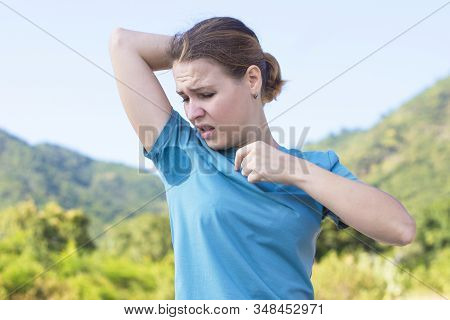 Sweating Young Girl Sniffing Her Armpit, Looking At The Spot, Sweat Stain On Her T-shirt With Disgus