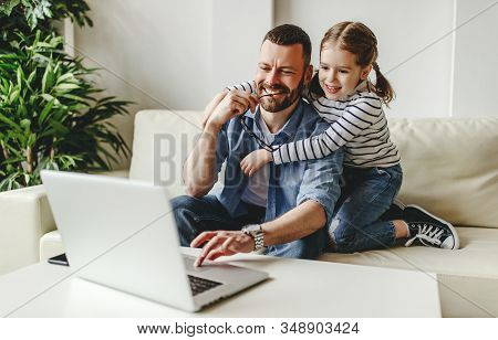 Happy Family A Businessman Father Working At Computer And His Child Daughter  At Home