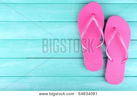 Bright flip-flops on color wooden background