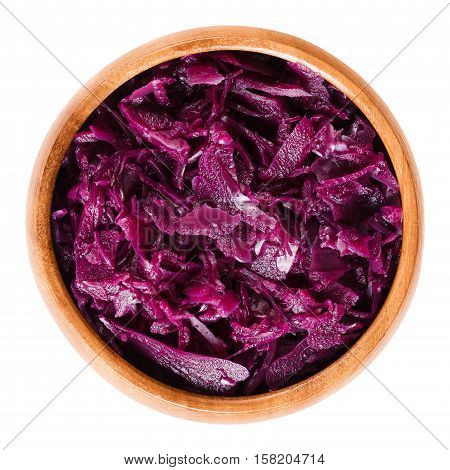 Cooked red cabbage in wooden bowl. Brassica oleracea, also purple cabbage, red or blue kraut. Used as a side dish for German meals. Isolated macro food photo close up from above on white background.