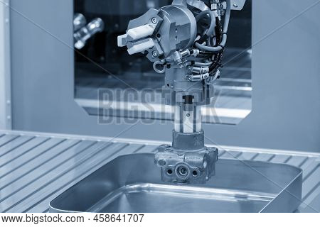 The Automatic  Robotic Arm Gripping The Metal Parts From Cnc Lathe Machine. The Hi-technology  Mater