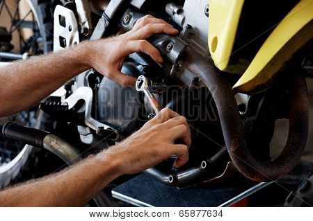 mechanic fixing motocycle engine