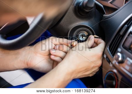 Close-up Of A Person's Hand Inserting Lockpickers Tools In Key Hole