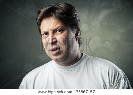 Man with disgusted expression over dark grey