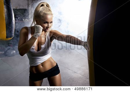 Young Woman Fitness Boxing In Front Of Punching Bag