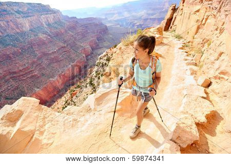 Hiker woman hiking in Grand Canyon walking with hiking poles. Healthy active lifestyle image of hiking young multiracial female hiker in Grand Canyon, South Rim, Arizona, USA.