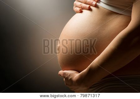 Pregnant Woman Belly. Pregnancy Concept. Isolated on Black Background. Pregnant tummy close up 