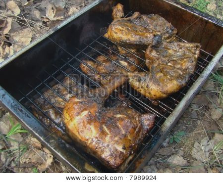 Casa fumeiro com pernas de frango defumado.