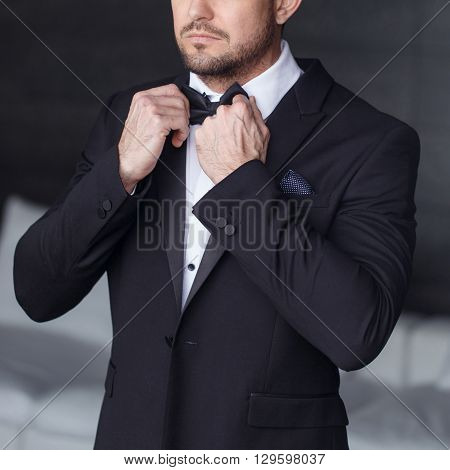 Sexy man dressing tuxedo and suit in luxury flat closeup