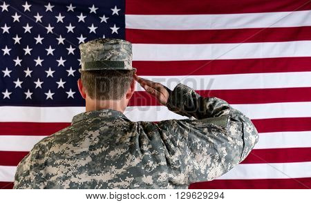 Male Veteran soldier back to camera saluting United States of America flag.