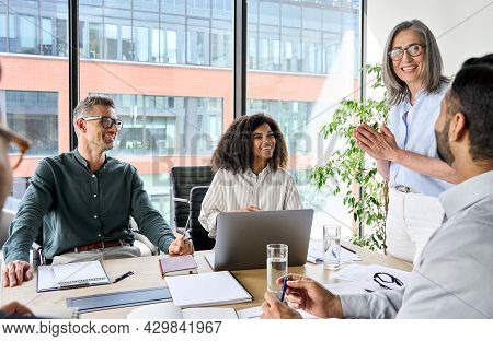 Senior Older Female Executive Ceo And Happy Multicultural Business People Discuss Corporate Project 