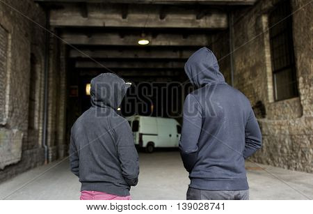 criminal activity, addiction, people and social problem concept - close up of addict men or criminals in hoodies on street