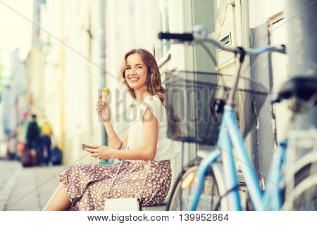 people, style, technology, leisure and lifestyle - happy young hipster woman with smartphone and fixed gear bike eating ice cream on city street