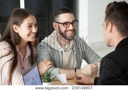 Excited Smiling Millennial Couple Discussing Mortgage Loan Investment Or Real Estate Purchase With R