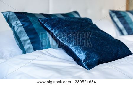 Blue Silky Hotel Room Bedding Pillows And Sheets On Bed.